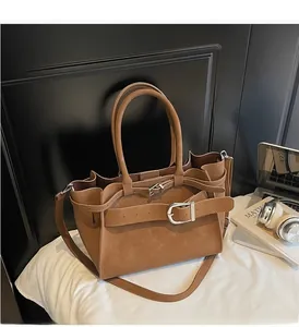 Detailed close-up of brown vintage leather tote bag with stylish buckle and soft handles