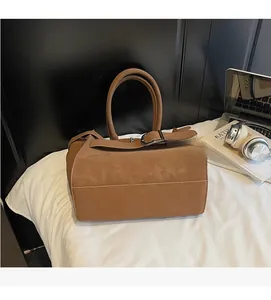 Close-up of brown vintage tote bag with elegant belt buckle and comfortable handles