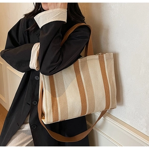 Close-up of a large capacity striped canvas tote bag with shoulder straps for women