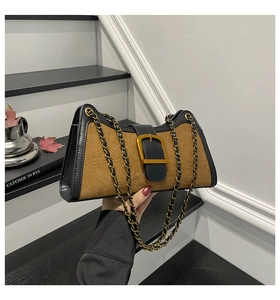 Close-up of vintage baguette bag with brown suede texture and gold metal buckle