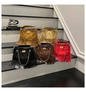 Detailed view of suede fringe bags with golden turn-lock buckles in various colors