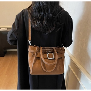 Detail view of brown matte vintage satchel with silver buckle and removable shoulder strap