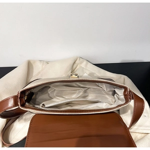 Close-up of retro crossbody bag interior with herringbone lining and golden metal clasp