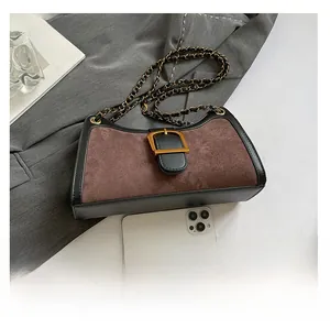 Top view of retro baguette bag with gold buckle and chain strap on grey fabric
