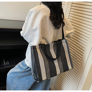 Detailed view of the large capacity striped canvas tote bag showing texture and shoulder fit
