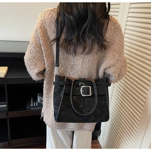 Detail of retro black matte tote bag with adjustable straps and silver metal buckle