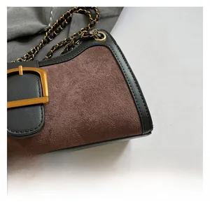 Detail showing brown suede and black leather stitching with vintage gold metal buckle