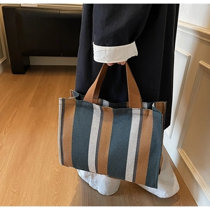 Detail of the large striped tote bag featuring brown and navy canvas with sturdy straps