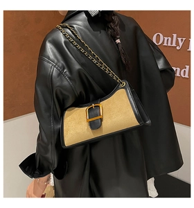 Detail of khaki suede baguette bag with black leather trim and gold buckle