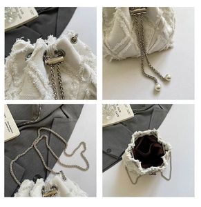 Detail view of cream drawstring bucket bag with fringe texture and pearl chain strap