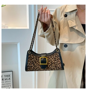 Detail of leopard print baguette bag featuring gold square buckle and chain strap