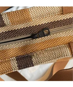 Detailed close-up of smooth black metal zipper on striped canvas tote bag texture