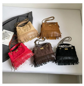 Flat lay of suede tassel shoulder bags in beige, brown, red, coffee, and black tones