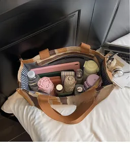 Macro view of a large striped canvas tote bag showing interior space with daily essentials