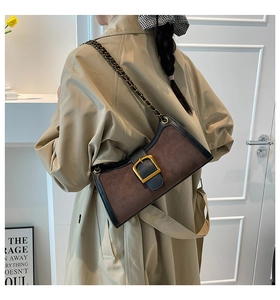 Detail of vintage baguette bag with brown suede finish and large gold buckle feature
