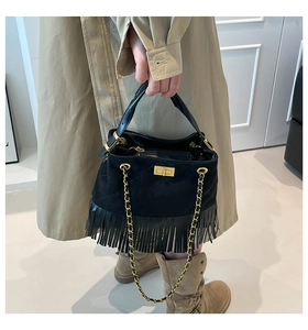 Detail of black suede tassel bag with diamond quilting and gold twist lock closure