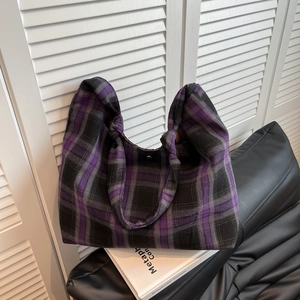 Détail du sac cabas à carreaux violet et noir sur un livre avec fermoir magnétique