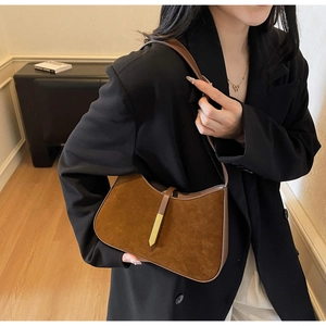 Detailansicht der Vintage Wildleder-Achseltasche mit Goldverschluss am Model