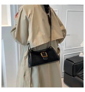 Detail of black baguette bag featuring premium matte leather and a gold square buckle