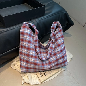 Détail du sac fourre-tout en toile à carreaux avec poignée nouée et motif tartan classique