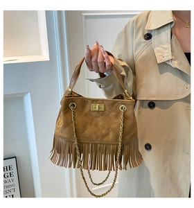 Detailed close-up of brown suede fringe bag with quilted patterns and gold rotary lock