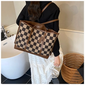 Classic checkered canvas tote bag with brown leather straps shown in a lifestyle setting