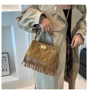 Detail of brown suede crossbody bag featuring diamond stitching and long tassels