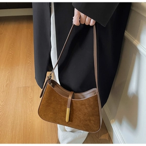 Nahaufnahme der braunen Wildleder-Unterarmtasche mit eleganter goldener Schnalle