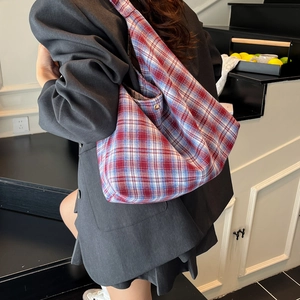 Détail du sac cabas en toile à carreaux rouge et bleu avec large bandoulière et fermoir
