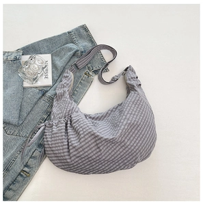 Detail view of the gray checkered croissant bag with drawstring and adjustable strap
