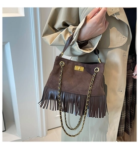 Detailed view of dark brown suede fringe bag with diamond quilting and gold lock