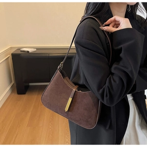 Detail einer braunen Wildleder-Schultertasche mit elegantem goldenem Metallverschluss