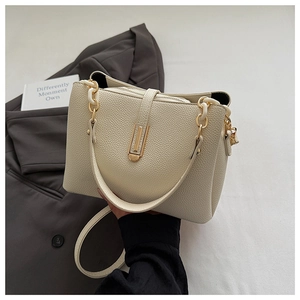 Detail of cream white lychee texture bag with gold hardware and stylish resin chain