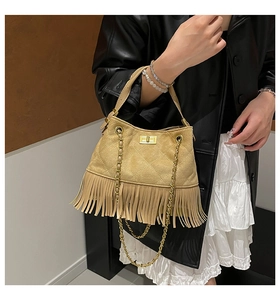 Detailed view of beige suede bag featuring quilted rhombic patterns and long dynamic tassels
