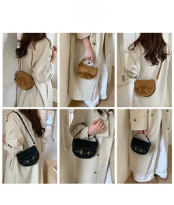 Detail of matte leather saddle bag showing dual metal buckles and vintage strap design