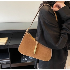 Nahaufnahme der braunen Wildledertasche mit goldenen Beschlägen und schmalem Gurt