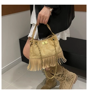 Detail of khaki suede fringed bag with quilted pattern and gold twist lock closure