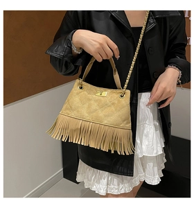 Brown suede quilted shoulder bag with fringe tassels and chain strap shown on a model