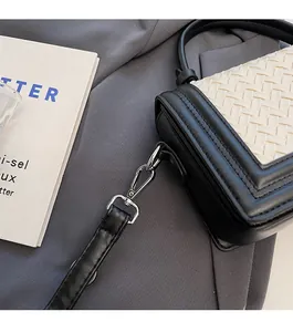 Detail of premium silver hardware and woven fabric on a stylish black and white bag