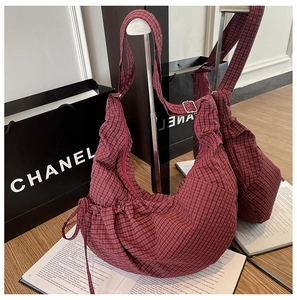 Detail view of the red plaid hobo bag featuring adjustable straps and drawstring design