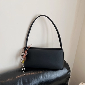Minimalist black matte leather baguette underarm bag with decorative colorful charms