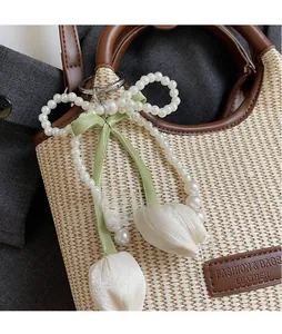 Nahaufnahme von Perlen-Tulpen-Taschenanhänger mit grünem Seidenband und Metallhaken