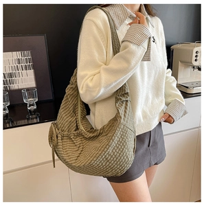 Detailed shot of green checkered dumpling bag with stylish drawstring pleated fabric