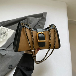 Vintage brown suede baguette bag with gold chain strap shown in a lifestyle setting