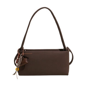 Retro brown baguette shoulder bag with leather heart and colorful charms on white background