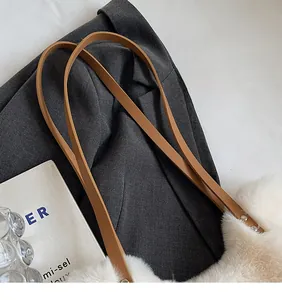 Detail der weißen Plüsch-Handtasche mit braunem Leder-Schultergurt und Metallnieten