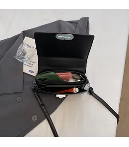 Interior view of black leather crossbody bag showing large capacity and multi-compartments