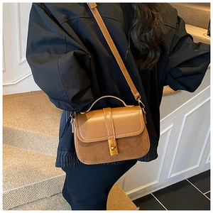 Detailed shot of brown contrast leather crossbody bag with metal twist lock for daily wear