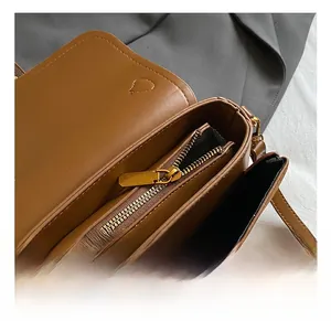 Detail view of brown leather bag interior with gold zipper and geometric lining