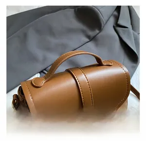 Close-up of brown PU leather shoulder bag with suede拼接 and gold metal hardware